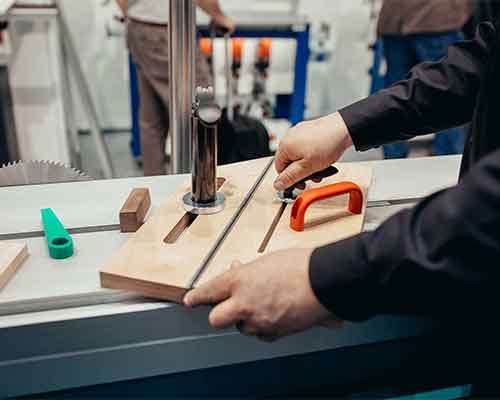 Cutting a wooden block on a table saw with a sliding jig