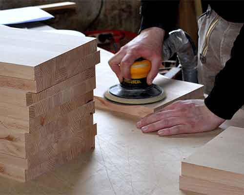 Sanding stacked pine panels with an orbital sander