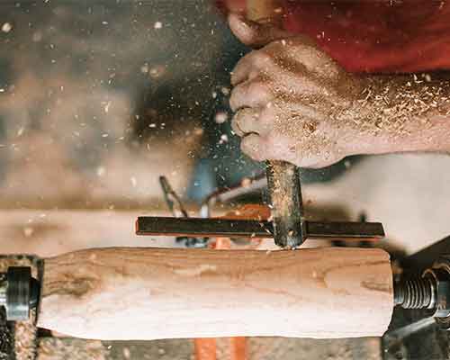 Shaping a wooden spindle on a lathe with a chisel