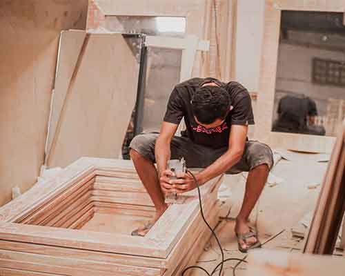 Carpenter assembling a plywood frame with a power tool